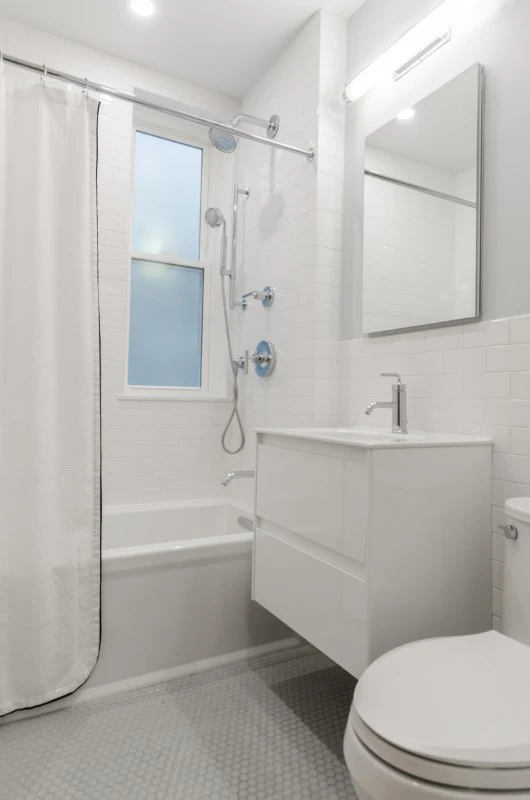 Baño pequeño de color blanco con bañera moderna